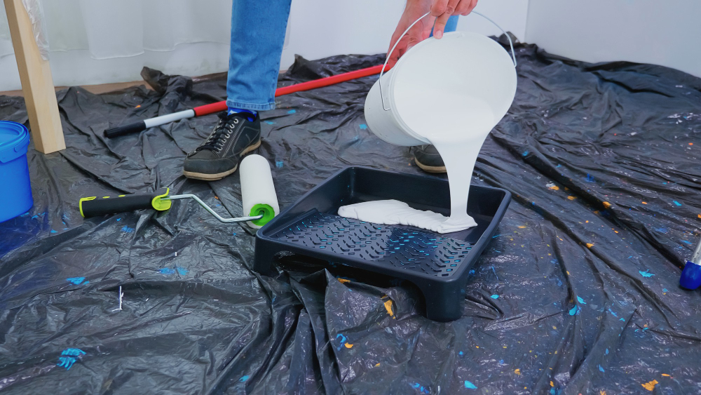man pouring paint on tray