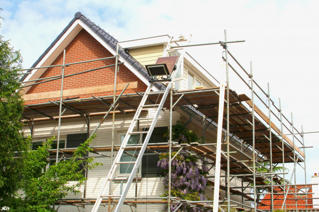 Renovation of a home exterior with construction equipment around it.