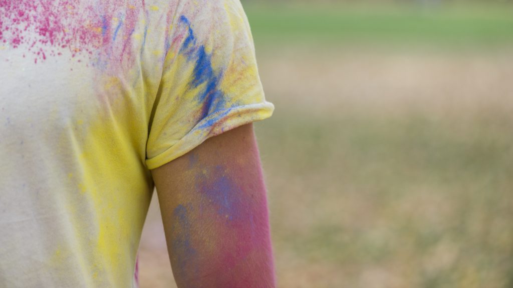 person wearing a white shirt with spray paint stains
